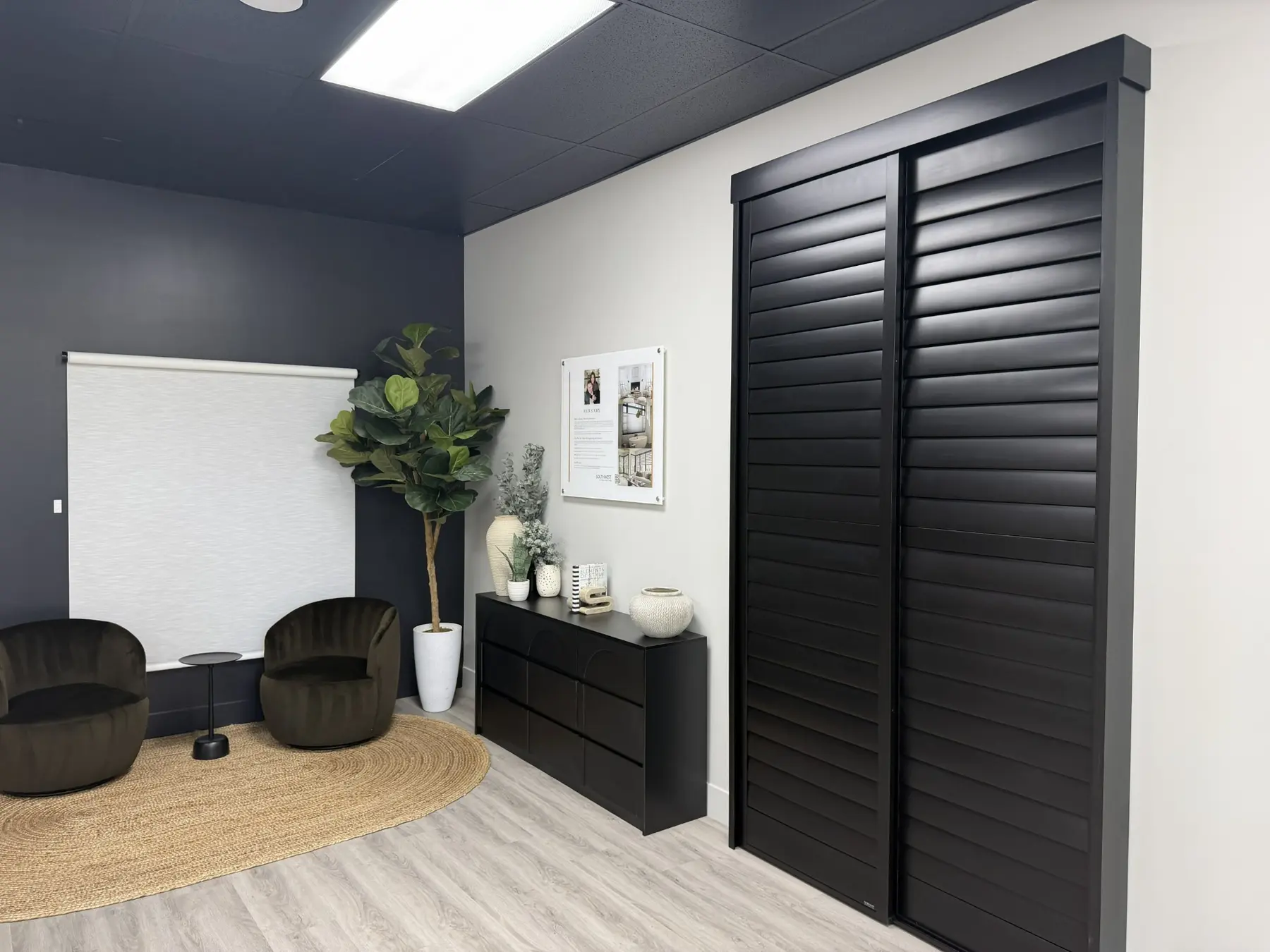 Updated Summerlin showroom design area with black shutters, a roller shade, and seating